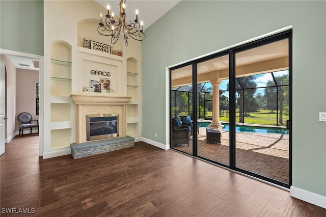 unfurnished living room with a healthy amount of sunlight, dark hardwood / wood-style flooring, and built in features