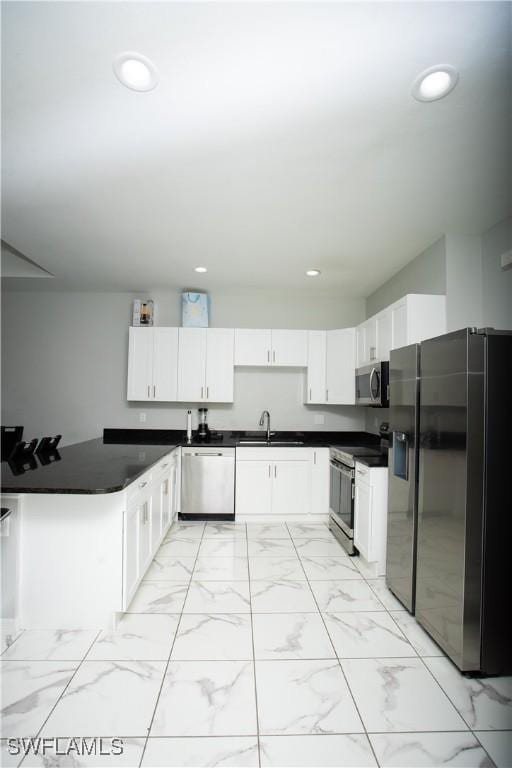 kitchen with stainless steel appliances, sink, and white cabinets