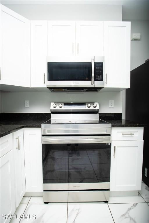 kitchen featuring white cabinetry, dark stone counters, and appliances with stainless steel finishes