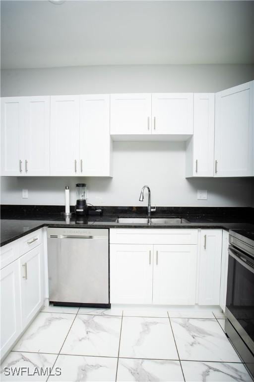 kitchen with appliances with stainless steel finishes, sink, and white cabinets