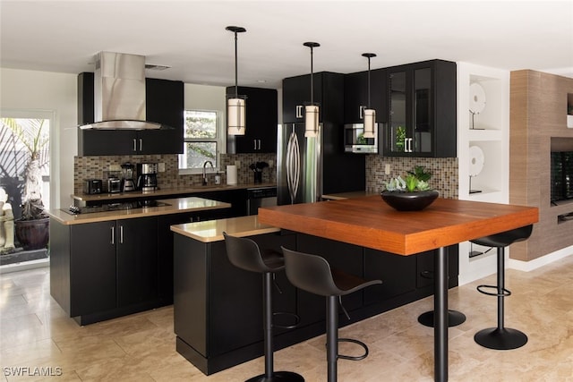 kitchen with sink, tasteful backsplash, a center island, pendant lighting, and exhaust hood