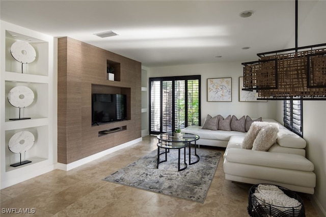 living room featuring light tile patterned floors and built in shelves