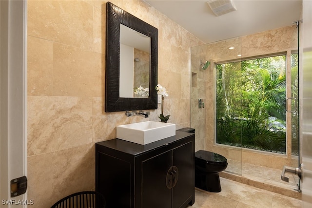 bathroom with vanity, tile walls, and toilet