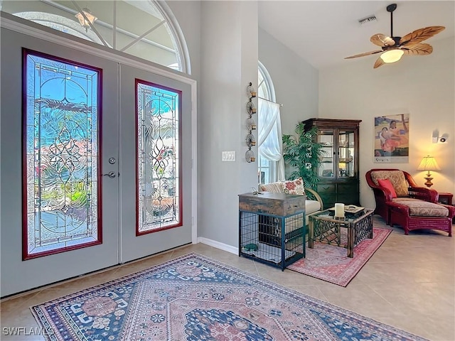 foyer featuring french doors, ceiling fan, and tile patterned flooring