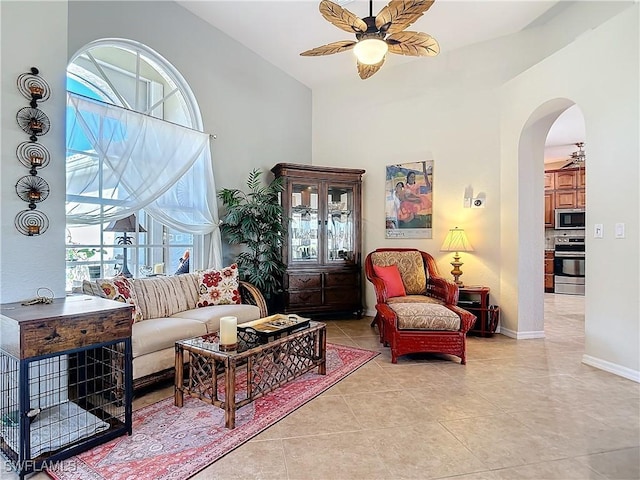 tiled living room featuring a towering ceiling and ceiling fan