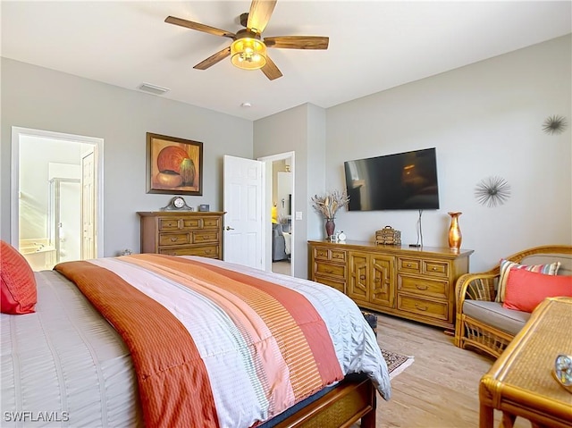 bedroom with ceiling fan, light hardwood / wood-style flooring, and ensuite bath