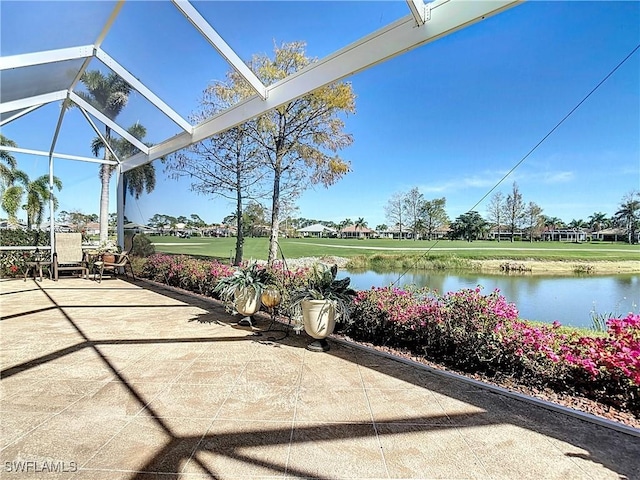 view of patio featuring a water view and a lanai