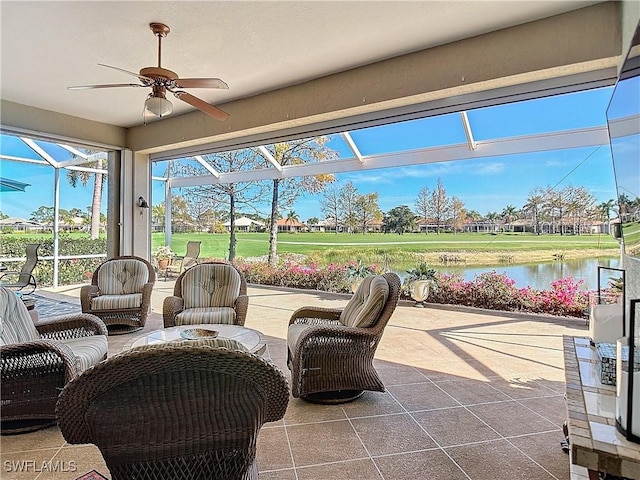 sunroom with a water view and ceiling fan