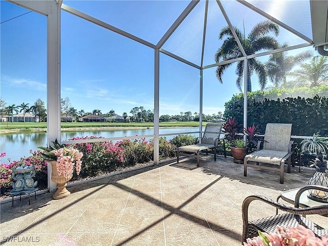 view of patio / terrace featuring a lanai and a water view