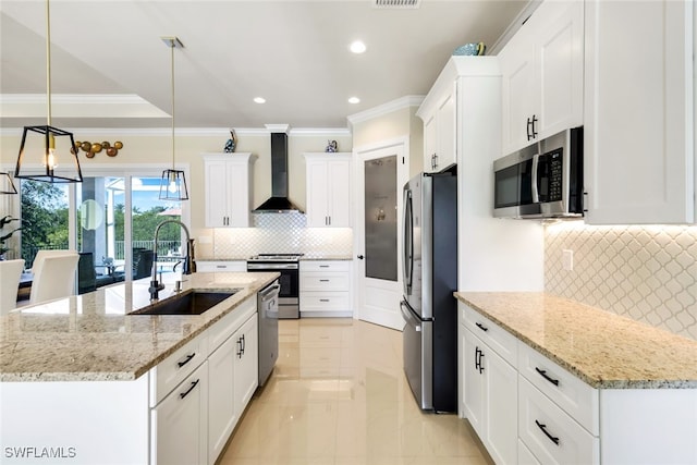 kitchen featuring pendant lighting, appliances with stainless steel finishes, an island with sink, and wall chimney range hood