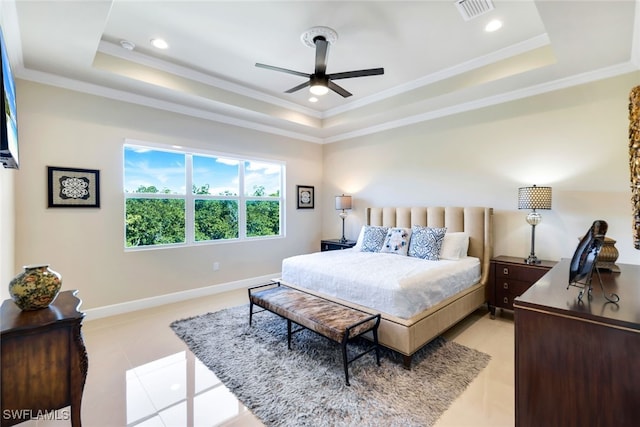 bedroom with ceiling fan, ornamental molding, a tray ceiling, and light tile patterned floors