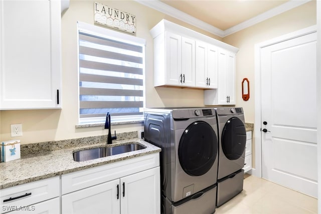 washroom with sink, crown molding, washing machine and dryer, and cabinets