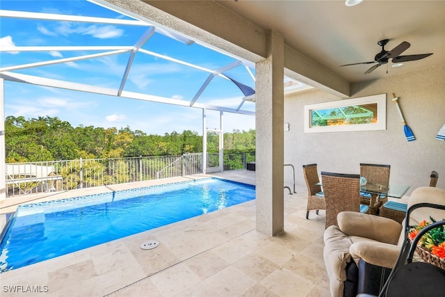 view of pool featuring glass enclosure, ceiling fan, and a patio area