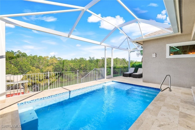 view of pool with a water view, glass enclosure, and a patio area