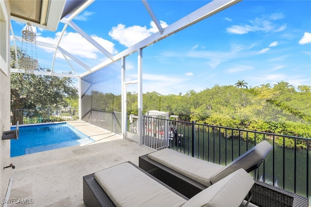 view of swimming pool featuring a patio, a water view, and glass enclosure