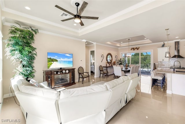 living room featuring crown molding, sink, ceiling fan, and a tray ceiling