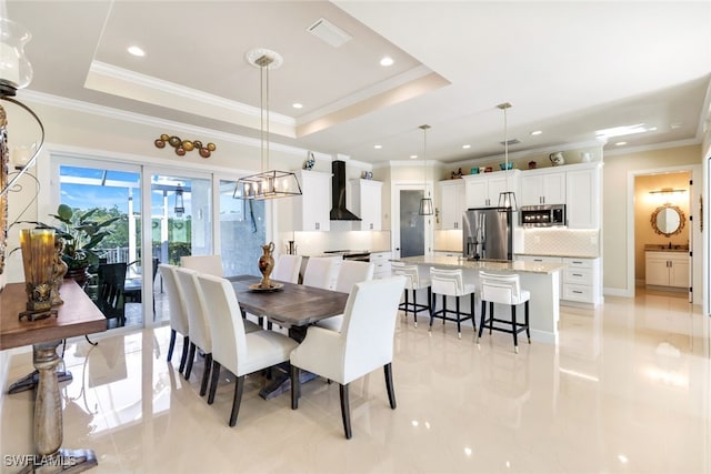 dining space featuring a tray ceiling and ornamental molding