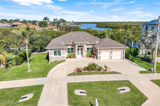 view of front of home with a water view, a garage, and a front yard