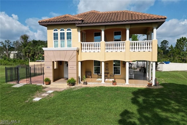 rear view of house featuring fence, a yard, a gate, stucco siding, and a patio area