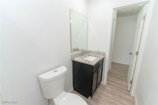 bathroom featuring vanity, hardwood / wood-style floors, and toilet