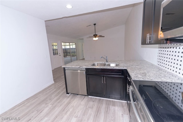 kitchen with sink, light wood-type flooring, kitchen peninsula, and appliances with stainless steel finishes