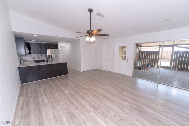 unfurnished living room featuring lofted ceiling, sink, ceiling fan, and light hardwood / wood-style flooring