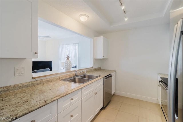 kitchen with sink, light tile patterned floors, appliances with stainless steel finishes, light stone counters, and white cabinets