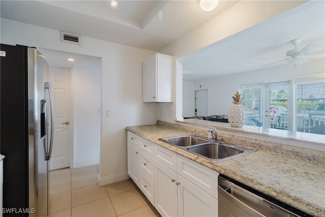 kitchen featuring sink, light tile patterned floors, ceiling fan, white cabinetry, and stainless steel appliances