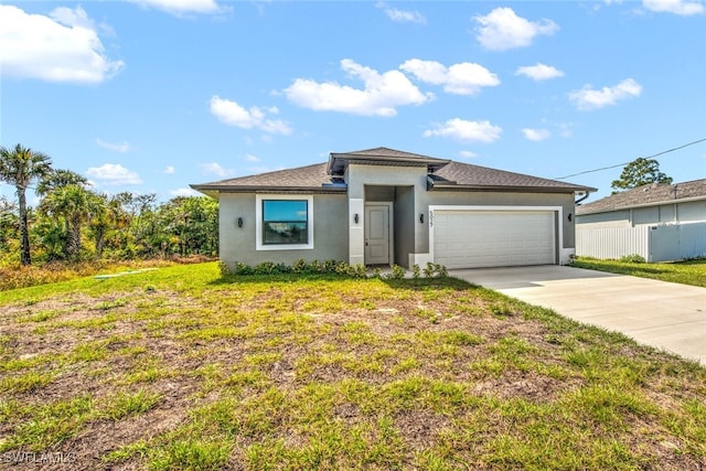 view of front of house with stucco siding, a front lawn, concrete driveway, and an attached garage