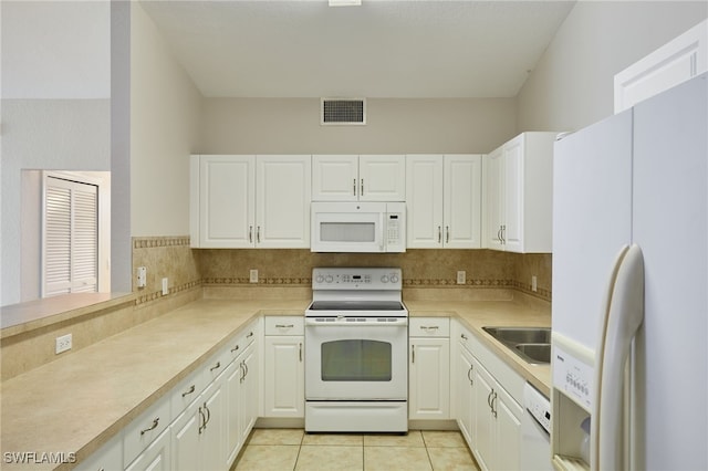 kitchen with light tile patterned floors, white appliances, a sink, visible vents, and light countertops