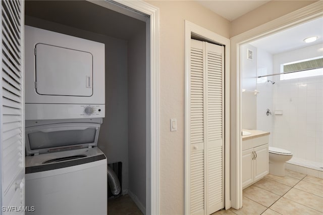 washroom with stacked washer / drying machine, visible vents, and light tile patterned floors