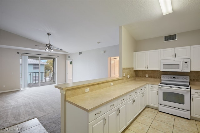 kitchen with visible vents, open floor plan, vaulted ceiling, white appliances, and a peninsula