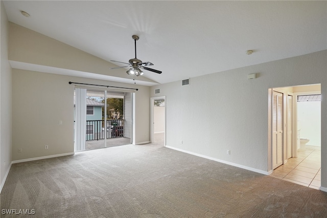 carpeted empty room featuring lofted ceiling, baseboards, visible vents, and ceiling fan