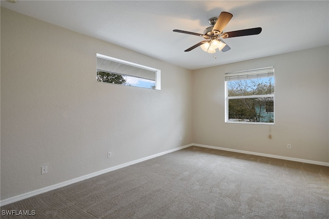 carpeted empty room featuring ceiling fan and baseboards