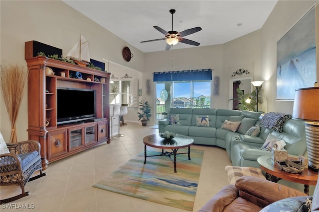 tiled living room with ceiling fan and a towering ceiling