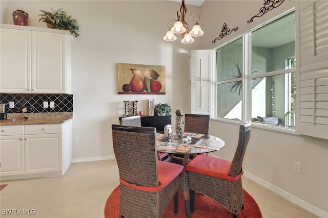 dining room with light tile patterned flooring and a notable chandelier