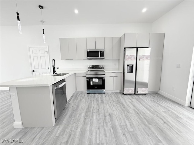 kitchen with sink, gray cabinetry, decorative light fixtures, stainless steel appliances, and light hardwood / wood-style floors