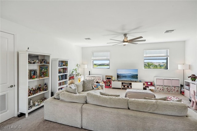 carpeted living area with visible vents and ceiling fan