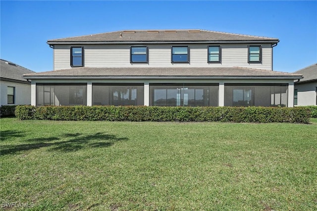 back of property featuring a lawn and a sunroom