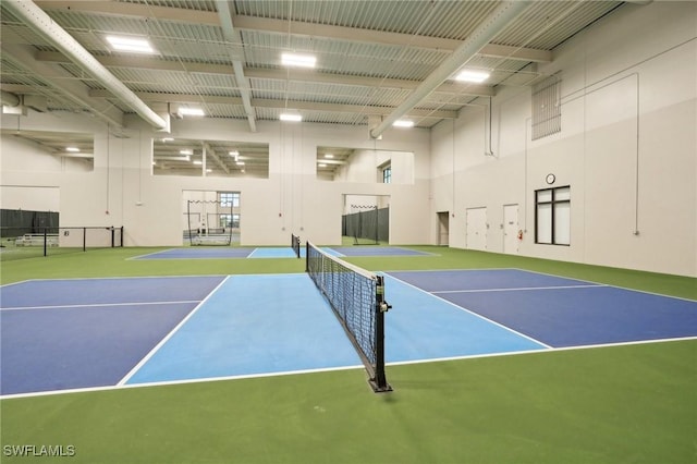 view of tennis court with community basketball court and fence