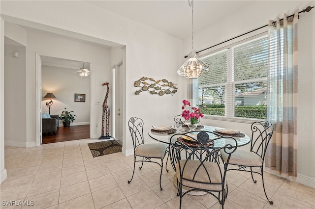 dining area with a ceiling fan, baseboards, and light tile patterned floors