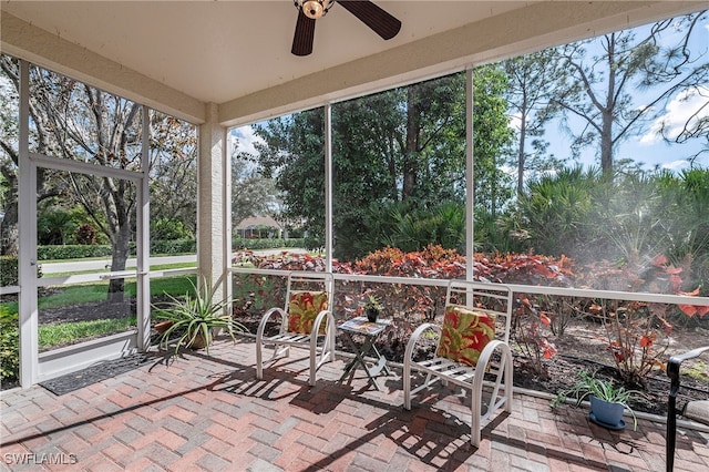 unfurnished sunroom featuring ceiling fan