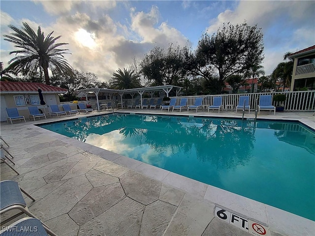 pool with a patio area and fence