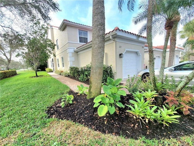 view of property exterior with a garage, a yard, a tile roof, and stucco siding