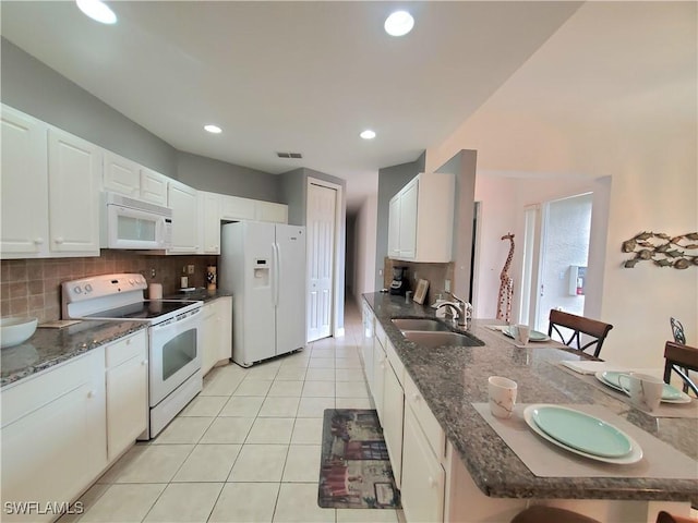 kitchen with white appliances, light tile patterned floors, sink, white cabinets, and tasteful backsplash