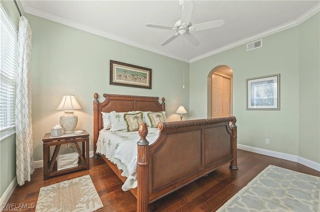 bedroom featuring baseboards, visible vents, arched walkways, dark wood-type flooring, and crown molding