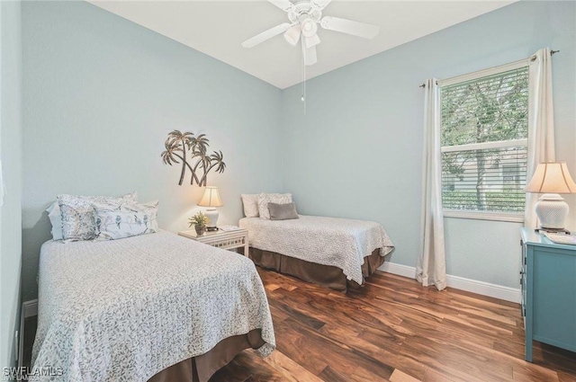 bedroom featuring dark wood-style floors, ceiling fan, and baseboards