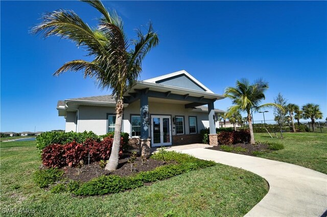 304 Spring Hill Lake Loop, Cape Coral, FL 33993 - view of front of house featuring french doors, stucco siding, and a front lawn
