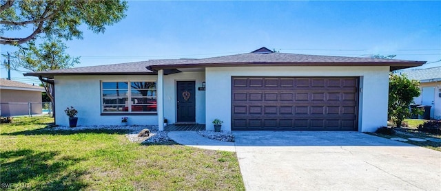 ranch-style house with a garage, a front yard, concrete driveway, and stucco siding