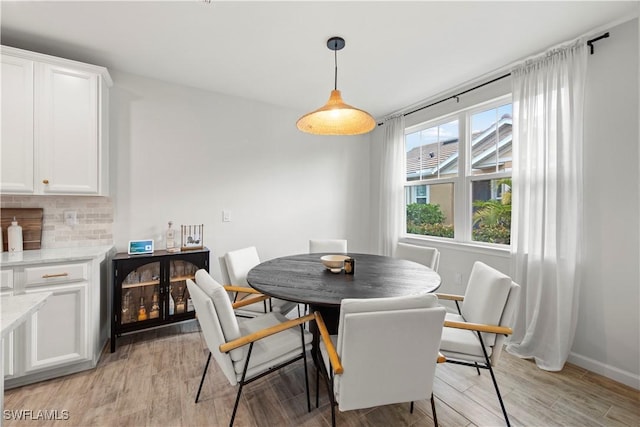 dining area with light wood finished floors and baseboards